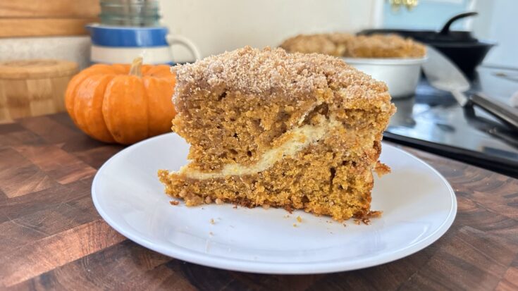 Pumpkin cream cheese coffee cake with a layer of cream cheese in the middle and streusel crumb topping on top.