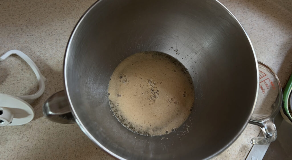 Bubbly, activated yeast in a mixing bowl.