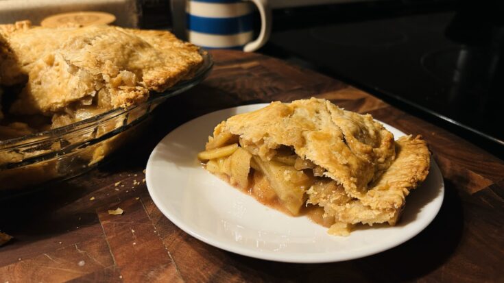 A slice of freshly baked rustic apple pie.