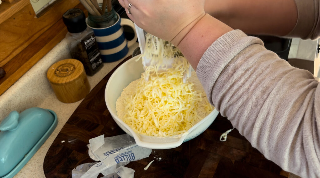 Grating cold butter into the dry ingredients for all butter pie crust.