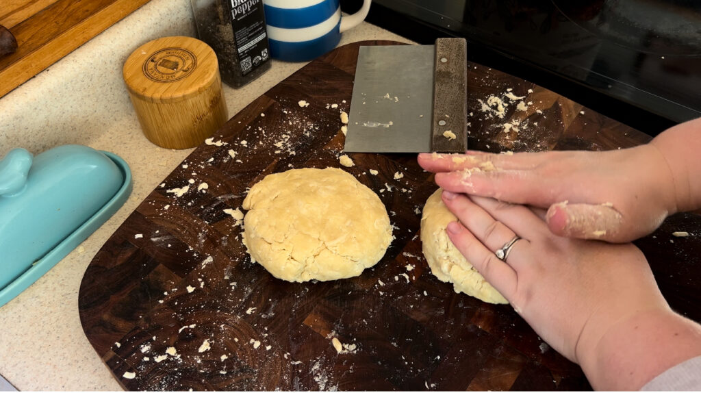 Making two round disks of pie crust dough for pie.