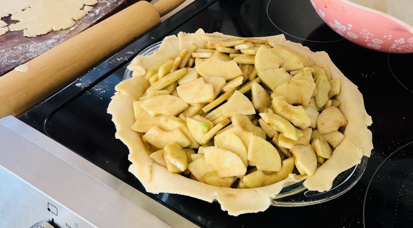 Chopped up apples made into an apple pie filling in pie crust waiting to be baked.