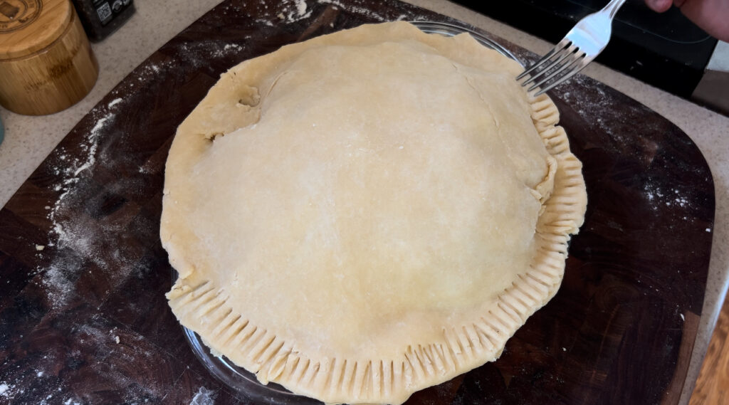 Crimping pie crust with a fork.