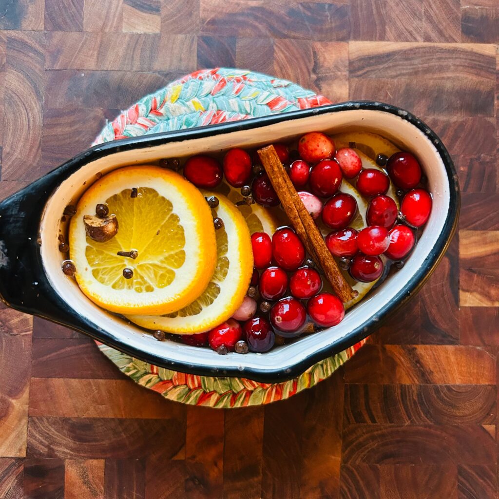 Simmer pot with freshly sliced oranges, cranberries, cinnamon and other spices.