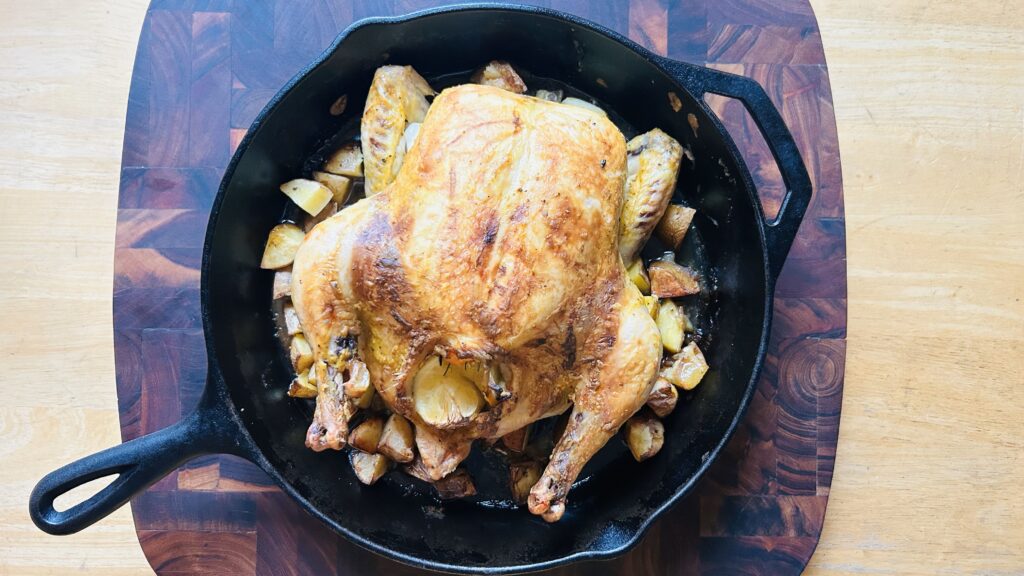 Easy roast chicken in a cast iron skillet with roasted potatoes. 