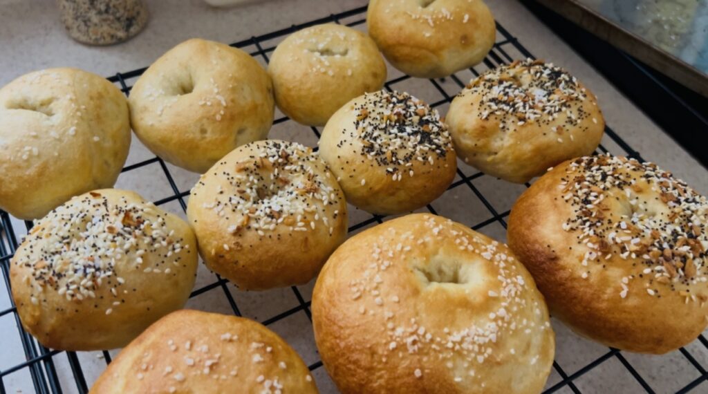 Freshly baked sourdough bagels cooling on a wire rack.