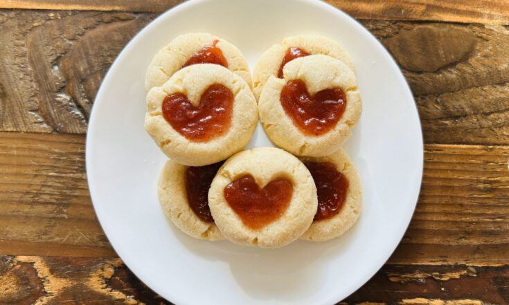 Small white plate with strawberry thumbprint cookies.