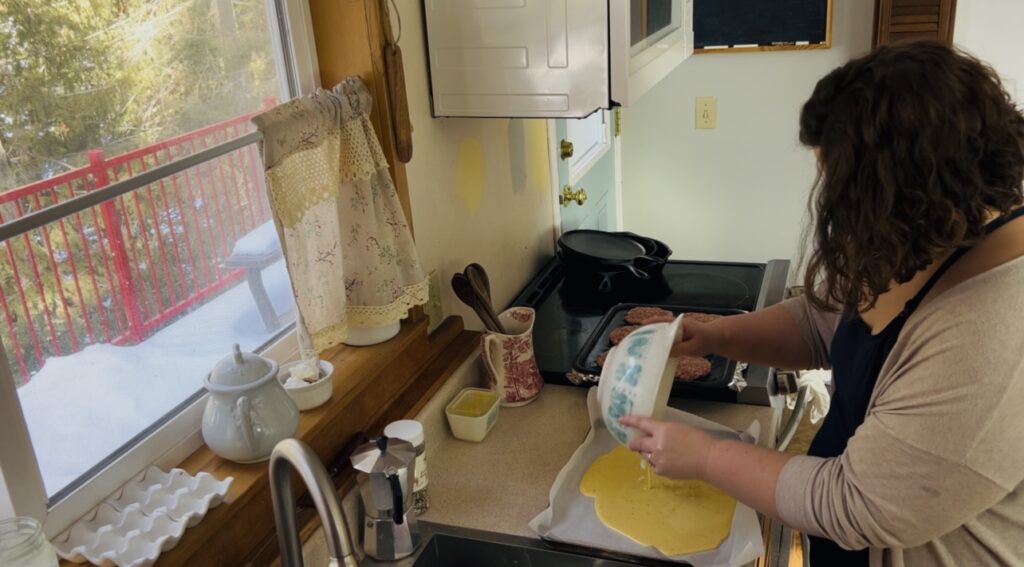 Woman preparing a pan of scrambled eggs for baking in the oven for breakfast sandwiches.