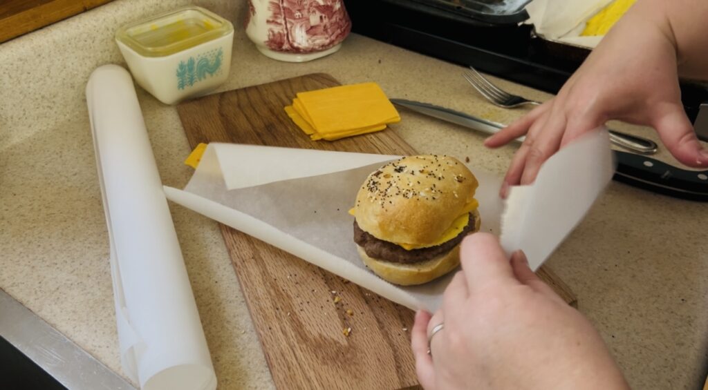 Wrapping a make ahead breakfast sandwich in parchment paper for storing.