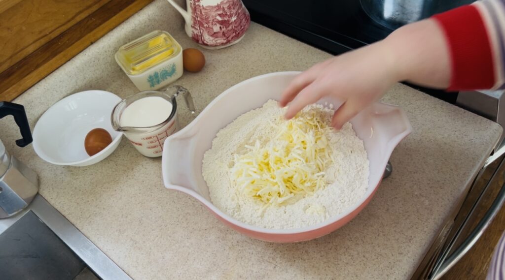 Mixing bowl of flour and grated butter for cutting in the butter to the flour.