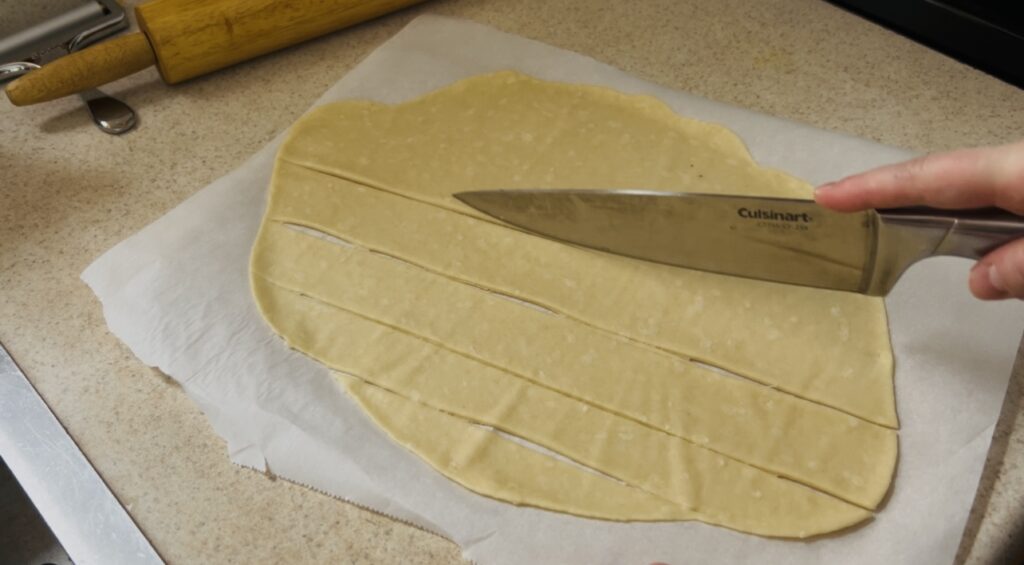 Cutting cracker dough with a knife.