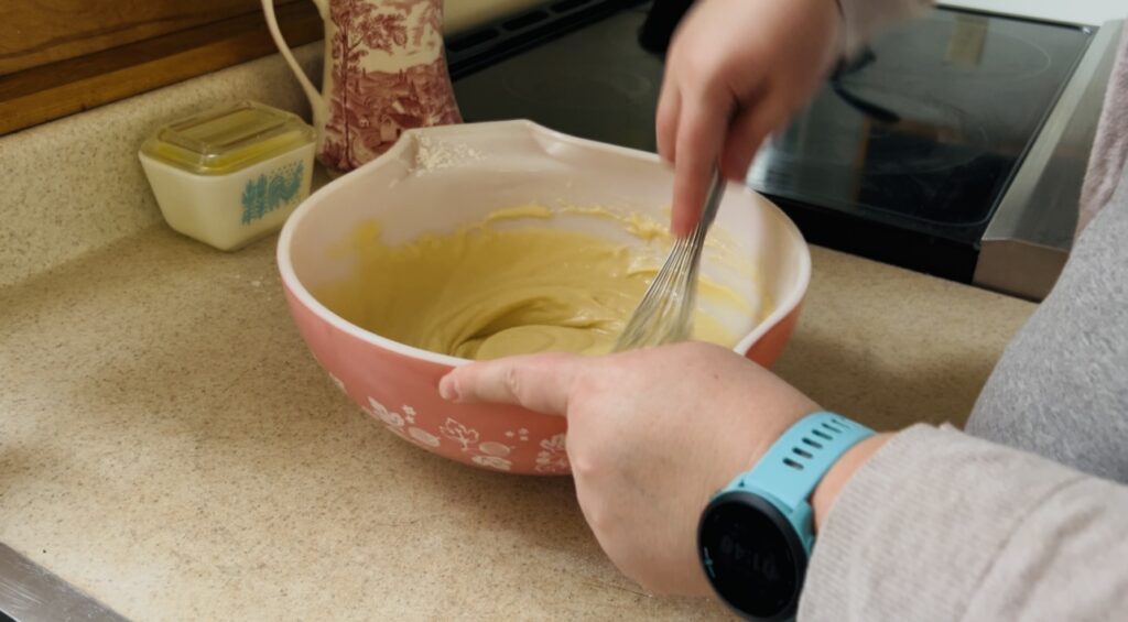 Whisking together the ingredients for vanilla cupcakes into a batter.