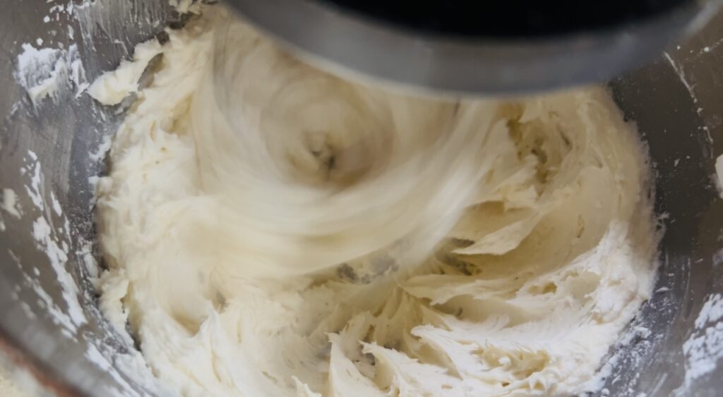 Vanilla buttercream frosting being whisked together in a stand mixer. 