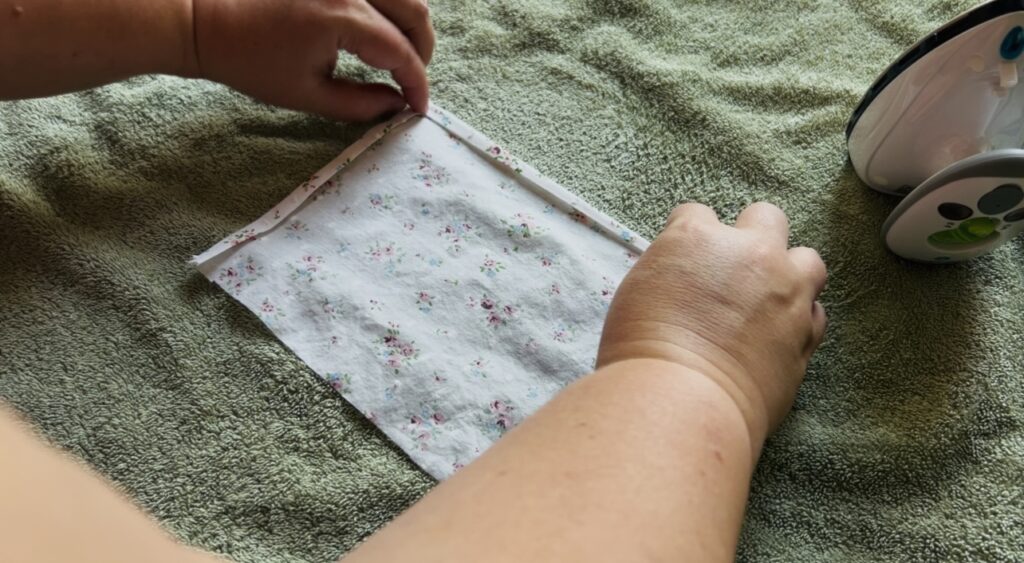Folding and ironing edges of the pockets for an apron.