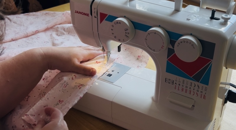 Sewing a basting stitch onto the waist of a waist apron.