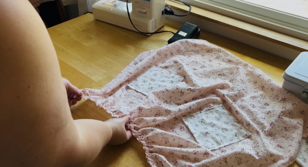 Adjusting the gathering on an apron to make it just right.