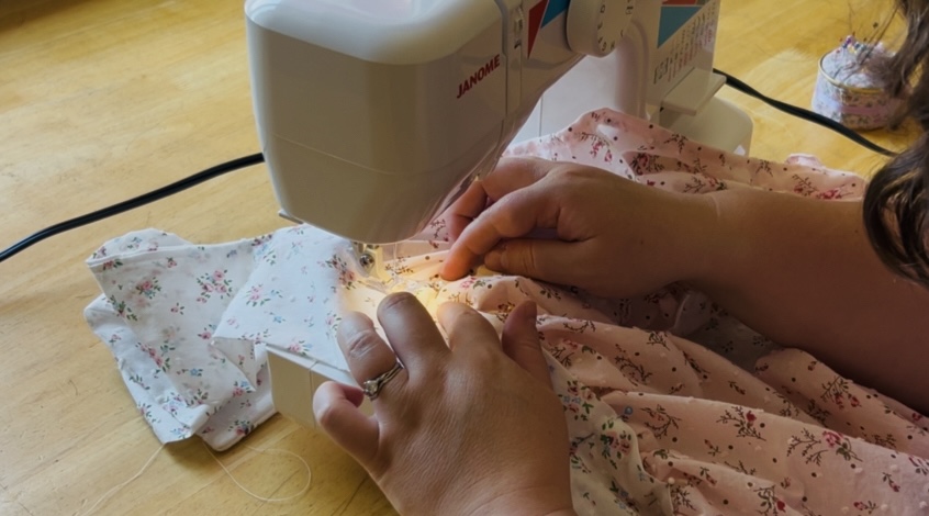 Sewing the waist band onto an apron skirt.