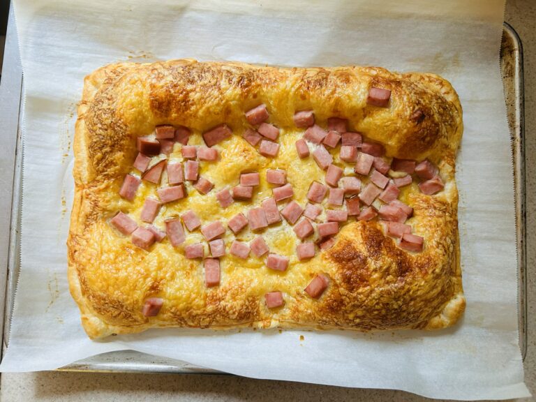 Golden, flaky puff pastry topped with cubes of ham and Swiss cheese, baked to golden perfection.